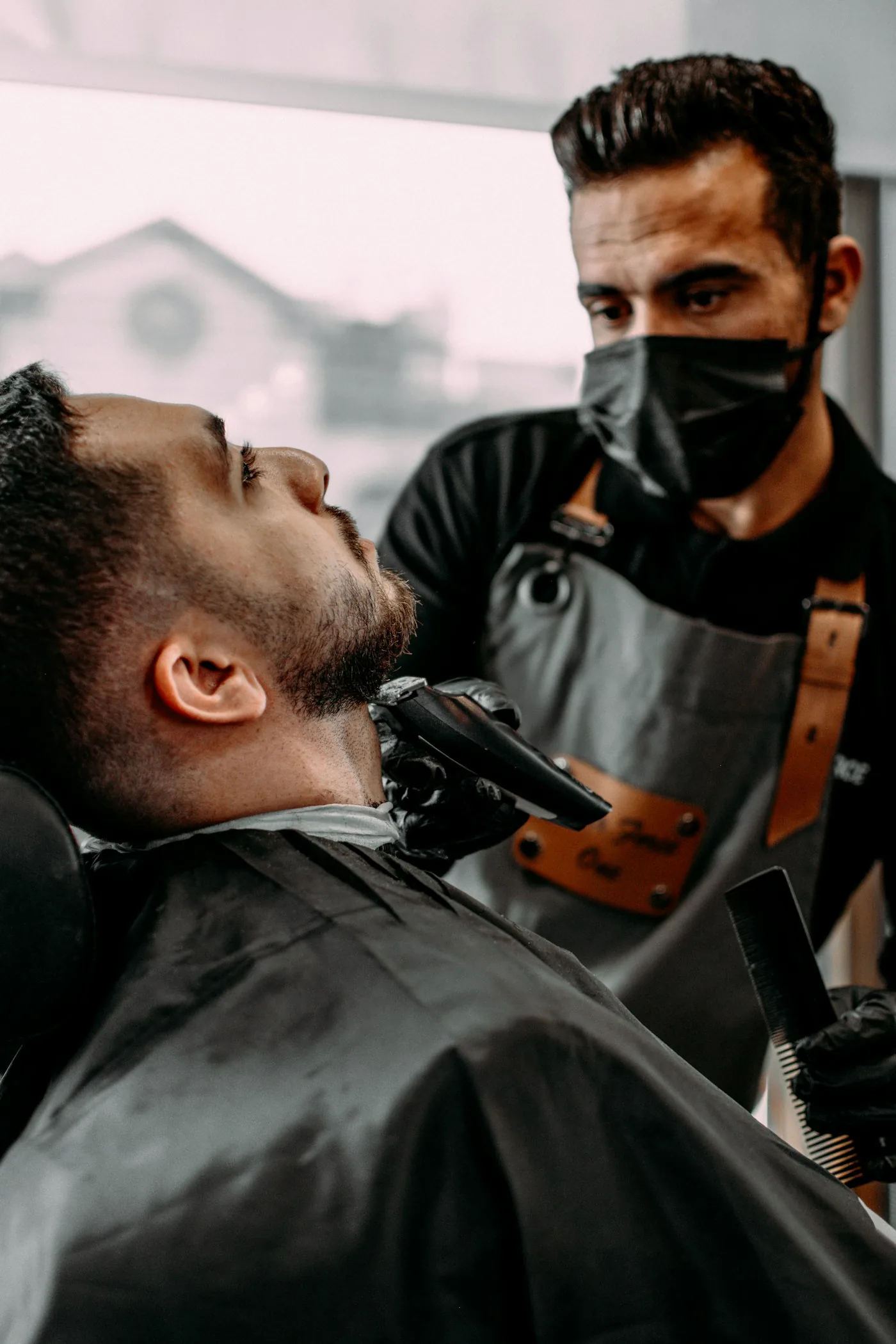 Barbeiro realizando acabamento de barba